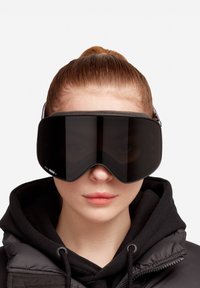Gafas de esquí con una gran lente oscura y curvada, un marco de espuma negra suave y una correa ajustable con un patrón para un ajuste seguro.