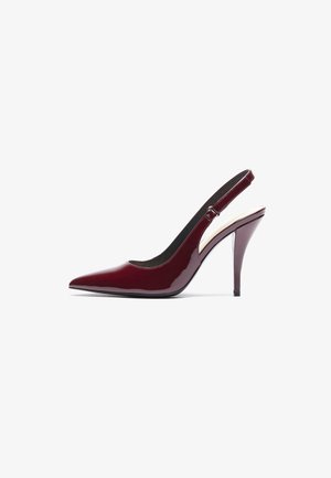 Escarpin à talon aiguille en cuir verni bordeaux avec un bout pointu et une texture lisse et élégante. Détail de sangle ajustable.