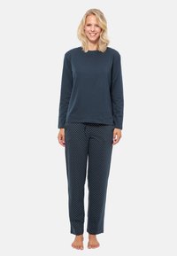Långärmad navy bomullströja kombinerad med navy pyjamasbyxor med prickar. Avslappnad passform, mjuk textur och elastisk midjeband.