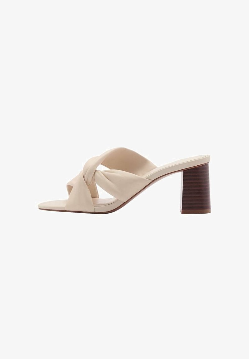 Mule beige à bout ouvert avec des brides tordues et un talon bloc en bois massif.