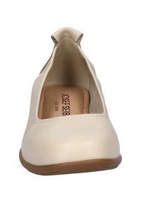 Beige leather slip-on shoe with a rounded toe, low rubber sole, and cut-out sides. Features interior cushioning and brand logo on insole.