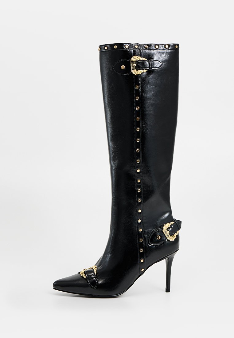 Czarne skórzane botki na wysokim obcasie do kolan z ostrym noskiem, złotymi ozdobnymi ćwiekami i złotymi dekoracyjnymi klamrami przy nosku, kostce oraz górnej krawędzi.