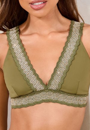 Maslinasto zelena bralette s dubokim V-izrezom, koja ima složeni teksturirani rub u krem i zlatu duž rubova i pojasu.