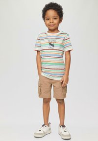 Pasiasty t-shirt z krótkim rękawem w kolorach niebieskim, pomarańczowym i zielonym z grafiką tekstową. Beżowe szorty cargo i białe trampki z szarymi akcentami.