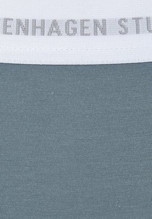 Grijze stof met een fijne ribbeltextuur. Witte elastische tailleband met een subtiele grijze logoafdruk. Close-up uitzicht met focus op materiaal en ontwerp.