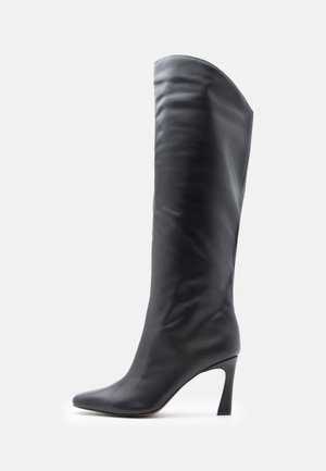 Bota de cuero negro hasta la rodilla con punta afilada y tacón de aguja delgado; textura suave, diseño estructurado y caña alta.