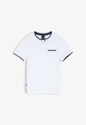 Biała koszulka z krótkim rękawem z granatowymi akcentami na kołnierzu i rękawach, z trzema guzikami na plastrze i kieszenią na piersi.