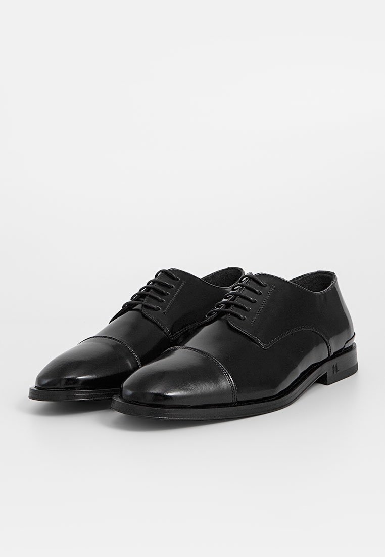 Schwarze Leder-Halbschuhe mit glänzender Oberfläche, Kappen-Design und Schnürverschluss. Verfügt über eine glatte Textur und eine elegante Silhouette.