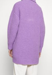 Cardigan en maille violet oversize avec col montant, texture côtelée et épaules tombantes, doté d'un ourlet droit.