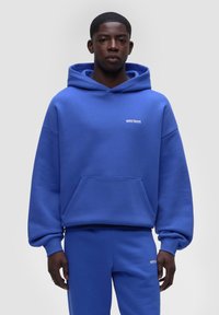 Felpa blu royal realizzata in tessuto morbido, con tasca frontale e cappuccio con cordino. Logo bianco esposto nell'area del petto.