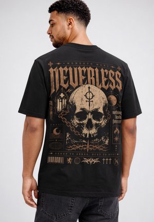 Mann trägt ein schwarzes T-Shirt mit großem beigen Totenkopf, Ketten, gotischen Symbolen und Text, darunter "NEVERLESS" und "nothing lasts forever" auf dem Rücken.