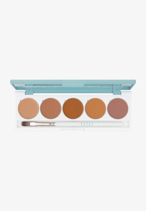 Cream makeup palette featuring five circular shades in tan and brown tones, housed in a white case with a light blue lid and a brush.