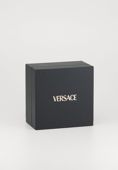 Čierna obdĺžniková krabica s textúrovaným povrchom, s pozláteným logom "VERSACE" na prednej strane. Žiadne viditeľné uchá ani ozdoby.
