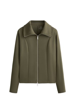 Veste vert olive en tissu lisse, dotée d'un col haut et d'une fermeture éclair intégrale à l'avant. Elle a une coupe ajustée avec des coutures minimales.