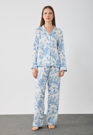 Blauw-wit bloemenpatroon pyjama set met een button-down blouse met lange mouwen en bijpassende loszittende broek.