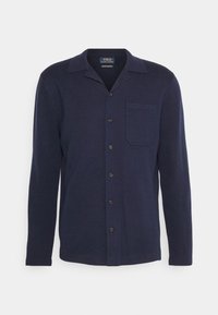 Marinblå långärmad knapplistad cardigan med en liten bröstficka på vänster sida och en platt krage.