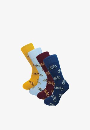 Quatre chaussettes colorées en jaune, bleu clair, bordeaux et marine, chacune ornée de petits motifs de vélos, présentées debout sur un fond blanc.
