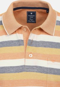 Koszulka polo z krótkim rękawem w pomarańczowe, białe i niebieskie paski. Posiada strukturalny kołnierzyk, zapięcie na trzy guziki oraz kieszonkę na piersi.