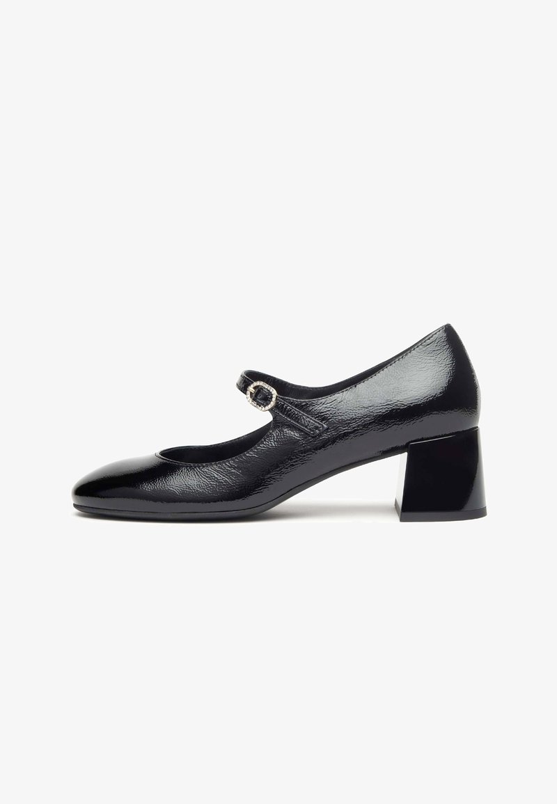 Black patent leather Mary Jane shoe with a round toe, featuring a buckle strap and a block heel. Smooth texture and minimalist design.