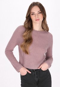 Lilac krāsas adīta džemperis ar garām piedurknēm, apaļu kakla izgriezumu un teksturētu rakstu, pārī ar augsto jostasvietu melnām denima biksēm.