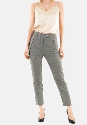 Pantaloni grigio a motivo houndstooth con vita alta, tasche con zip e vestibilità affusolata; abbinati a un top in satin crema.