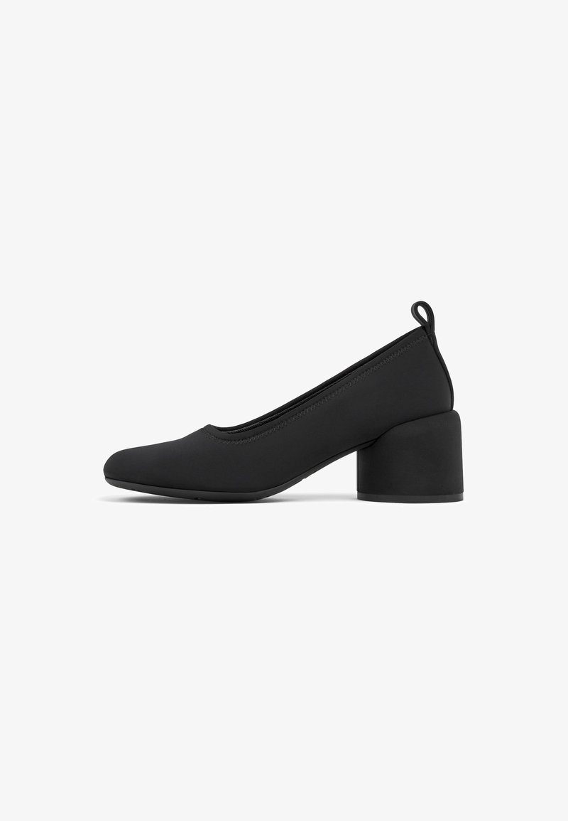 Black block-heeled pumps with a rounded toe and smooth fabric upper. Features a subtle pull tab at the back and stitch detailing along the seams.