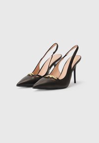 Musta satiini slingback-korkokengät, joissa on terävät varpaat, etuosassa kultaketjun yksityiskohta ja hoikka stiletto-korko.