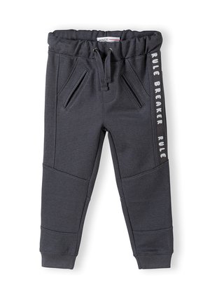 Ciemnoszare spodnie dresowe z elastycznym pasem, sznurkiem, bocznymi kieszeniami oraz białym napisem "RULE BREAKER" po boku. Teksturowana tkanina.