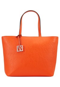 Pomarańczowa torba typu tote z ekologicznej skóry, ozdobiona tłoczeniem, podwójnymi uchwytami oraz srebrnym logo. Gładka tekstura i wyraźnie zarysowany kształt.