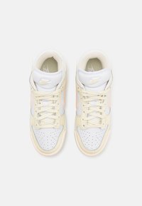 Hohe Sneakers aus weißem und hellbeigem Leder, mit einem blassen rosa Swoosh, perforierter Zehenpartie und strukturiertem Mesh-Zunge.