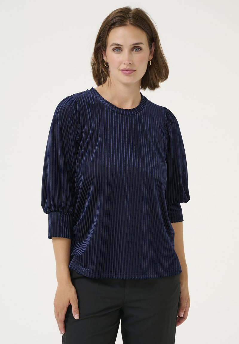 Top in velluto blu navy con righe verticali, scollo rotondo e maniche a tre quarti arricciate; texture morbida e vestibilità rilassata.