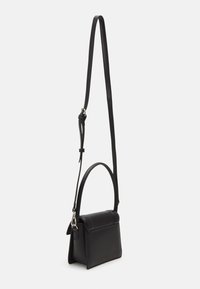 Sac à main en cuir noir au design structuré, doté d'une poignée supérieure et d'une bandoulière réglable. Texture lisse avec des détails minimalistes.