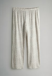 Spodnie w leopardzi wzór, wykonane z lekkiego materiału, z elastyczną talią i prostymi nogawkami. Paleta kolorów obejmuje beż i brąz.