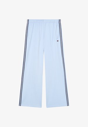 Jasnoniebieskie spodnie o szerokich nogawkach z granatowymi podwójnymi paskami po bokach i elastyczną talią, z małym logo Champion na prawym kieszeni.