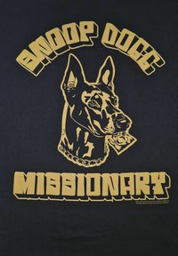 Černé tričko s obrázkem zlaté hlavy psa nosícího řetěz. Nápis nahoře zní "SNOOP DOGG" a dole "MISSIONARY."