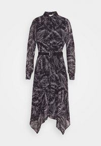 Longue robe noire avec motif de feuilles blanches, manches longues, fermeture boutonnée devant, ourlet asymétrique et ceinture noire à la taille.