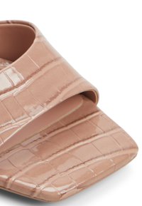 Sandal in finta pelle di coccodrillo rosa con una fascia larga e punta quadrata. Texture liscia e finitura lucida, progettata per una facile indossabilità.