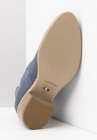 Blauwe schoen met een gestructureerde bovenkant en een beige rubberen zool. Maat 37, gelabeld met "Nerocaridini" en "Made in Italy" op de zool.
