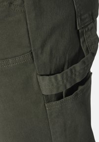 Olive green cargo pants with a textured fabric, featuring a side pocket and reinforced stitching. The design includes belt loops and adjustable straps.