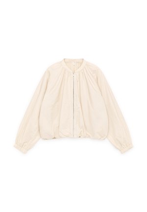 Veste courte beige avec un col rond, des poignets élastiques et une fermeture éclair frontale. Confectionnée dans un tissu léger à la texture lisse.