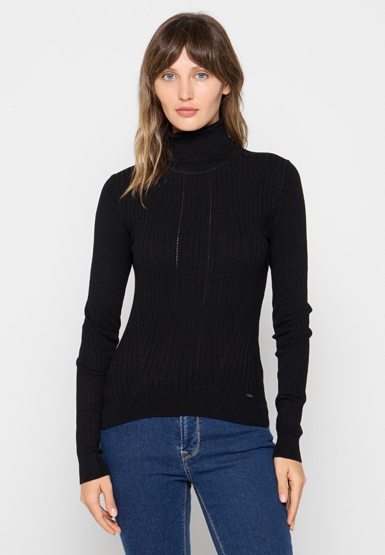 Pull à col roulé noir en tissu côtelé, avec un design ajusté et de subtils détails de couture sur le devant.