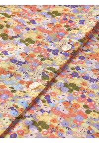 Pestrobarevná květinová bavlněná blůza s kombinací oranžové, růžové, fialové a zelené barvy, s kulatými bílými knoflíky a jemnou texturou.