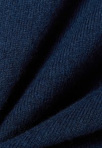 Dunkelblaues gestricktes Material mit einer weichen Textur. Es weist ein dezentes Rippenmuster auf und zeigt eine enge Webart sowie eine leichte Flauschigkeit.