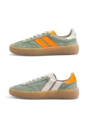 Deux baskets en daim vert avec semelles en gomme, lacets blancs et bandes contrastantes orange sur l'une et blanches sur l'autre, vues de profil.