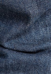 Tume sinine denimpind, millel on silmapaistvad kaltsukud, pehme tekstuur ja kerge sära, millel on hõbedased niidid koos. 