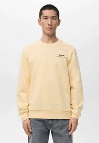 Lichtgele sweatshirt met een ronde hals, lange mouwen en een frontlogo op de borst met de tekst "Barcelona." Gemaakt van zacht katoenmixmateriaal.