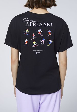 Black t-shirt with colorful illustrations of skiers in various poses and the text "Chiemsee APRÈS SKI" on the back.