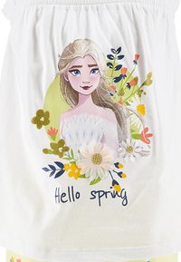 Weißes Baumwolloberteil mit floralem Design, Charakterillustration, dem Text "Hallo Frühling" und verschiedenen bunten Blumen und Laub.