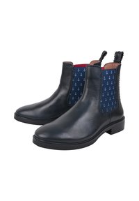 Sorte læder Chelsea-støvler med marineblå elastik på siderne, der har små hvide anker mønstre. Tekstureret trækflig bagpå. Glat overflade.