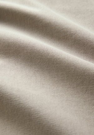 Beiger Stoff mit einer glatten, strukturierten Oberfläche, die subtile horizontale Linien und Falten zeigt, die Weichheit und Flexibilität anzeigen.